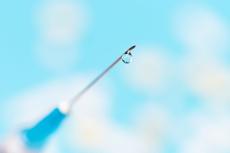 close up. drop of medicine on the needle of a syringe. photo with a copy-space.