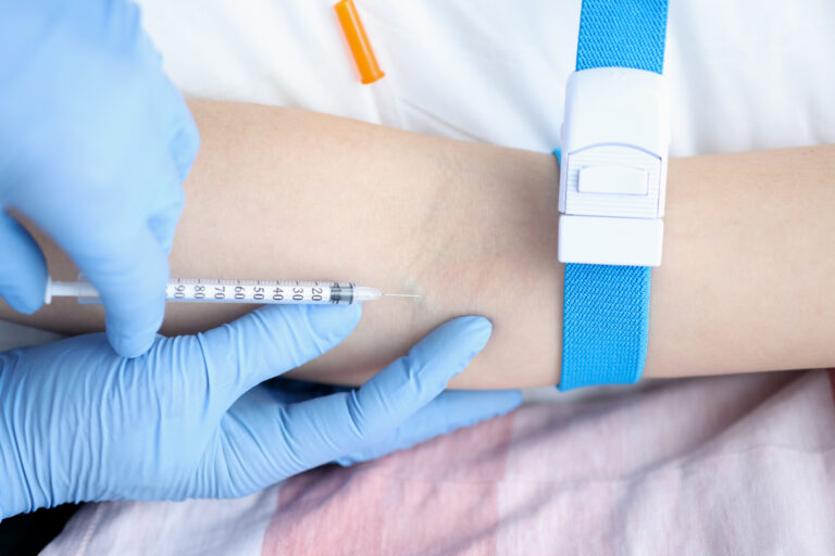 Nurse giving intravenous injection of medication to patient closeup. Blood sampling from a vein concept